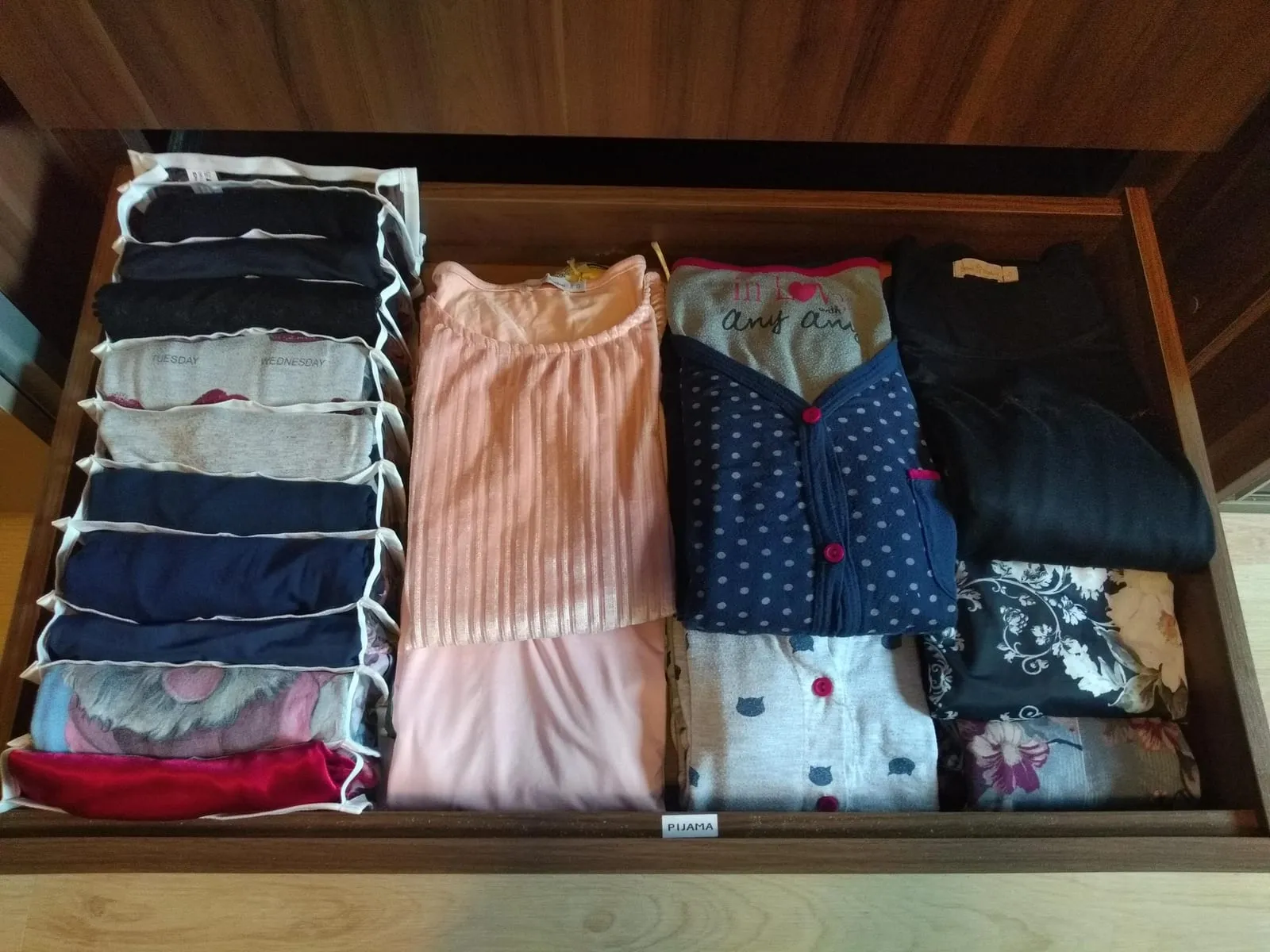Cajón de pijamas con un separador de tela para las prendas dobladas en vertical y el resto agrupado por tipo.