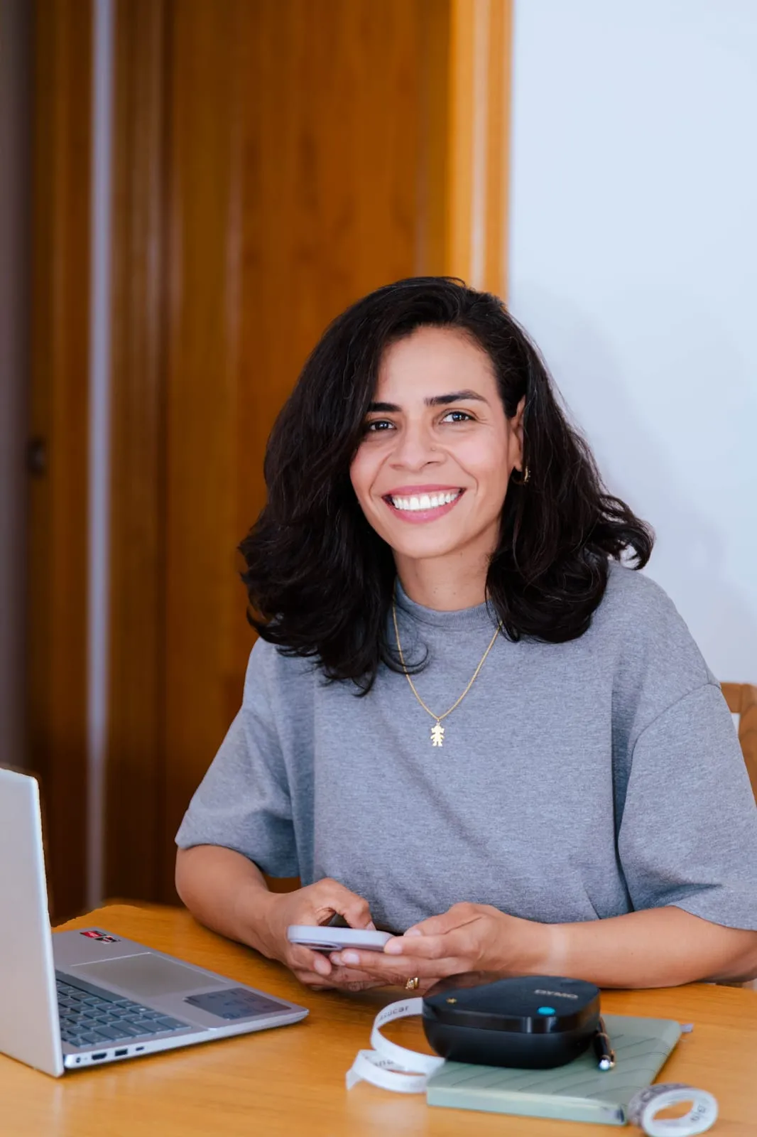Cris Cabrera, organizadora profesional, sonriendo en su mesa de trabajo.