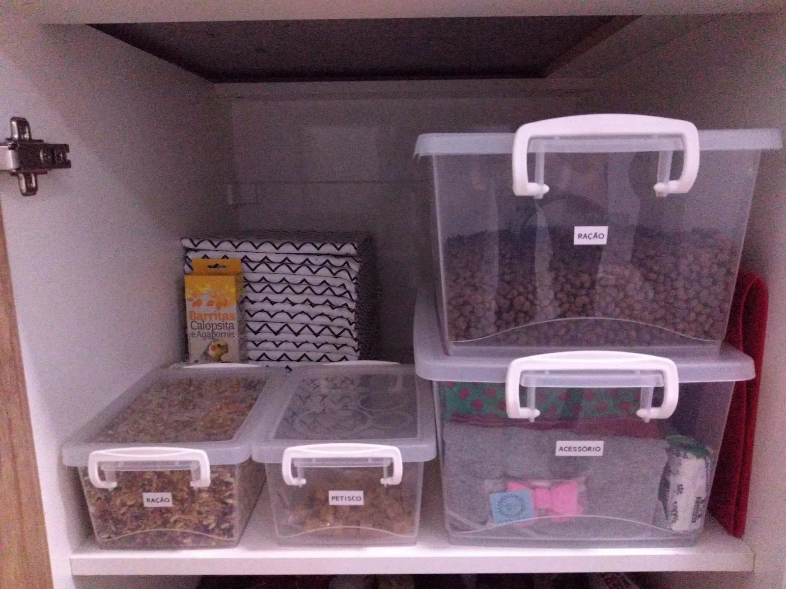 Balda con cajas transparentes con asas y etiqueta, apiladas por categoría.