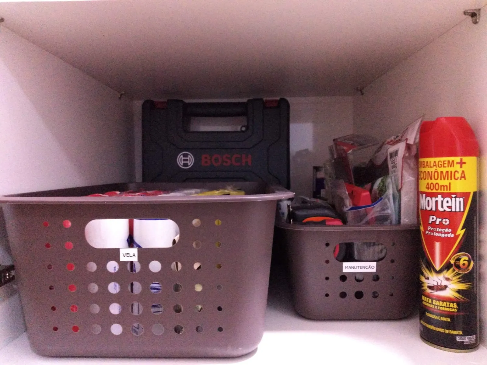 Balda con cestas etiquetadas para herramientas y productos de mantenimiento de la casa.